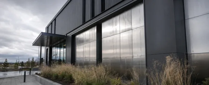 Exterior view of a modern commercial building with sheet metal facade panels exposed to outdoor weather